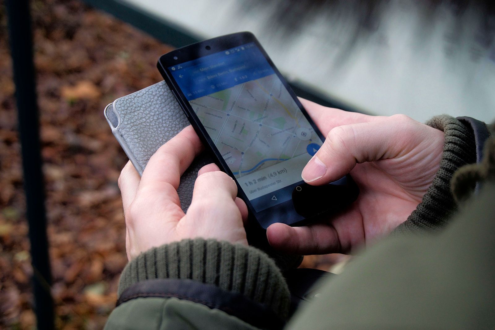 Ruka drží smartfón s otvorenou aplikáciou Google Mapy