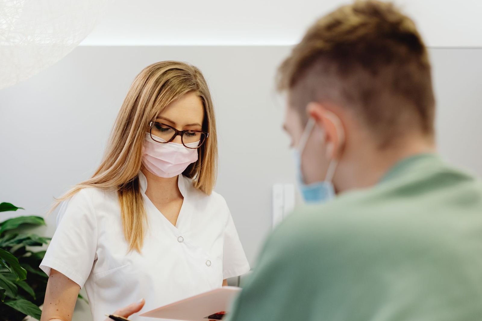 Recepcia ambulancie, sestra vysvetľuje pacientovi objednanie termínu